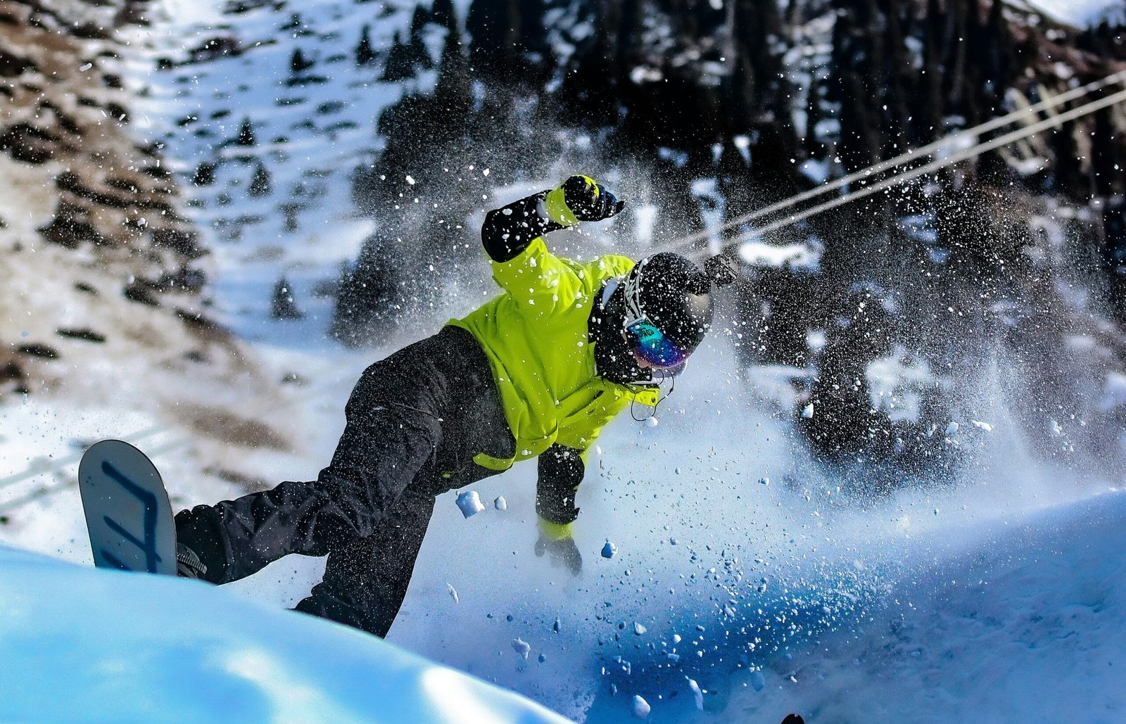 a man riding a - NewsOk a man riding a snowboard down the side of a snow covered slope